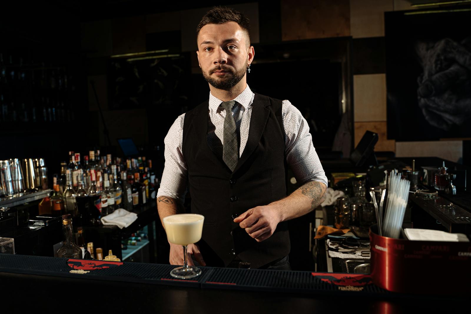 Professional bartender in a stylish Madrid lounge bar serving a cocktail