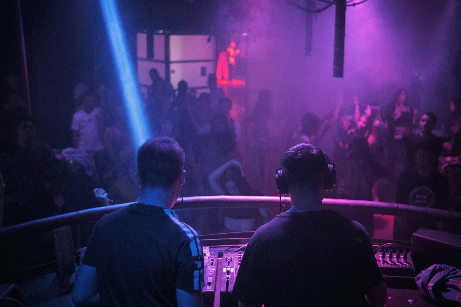 Lively Madrid nightclub with DJ mixing amid vibrant lights
