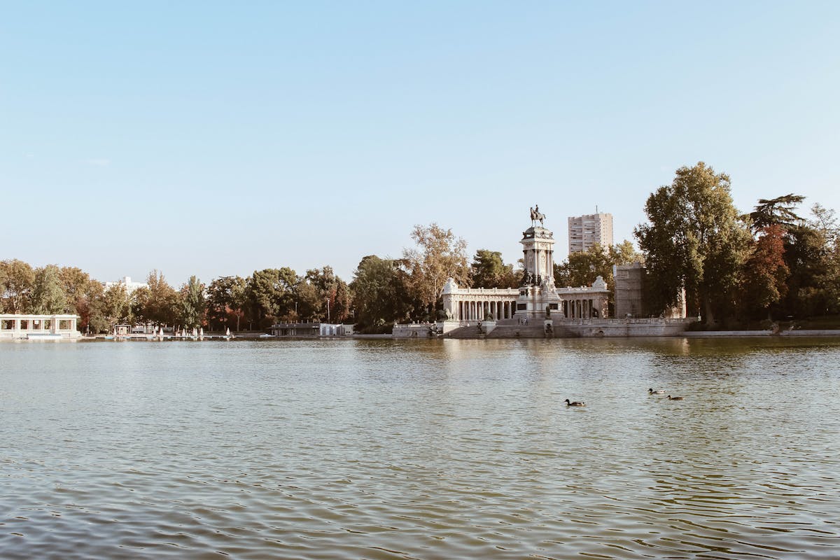 Things to Do in Madrid: The Ultimate Guide to Madrid's Best Attractions & Activities 6 Monument and lake at El Retiro Park in Madrid under blue sky