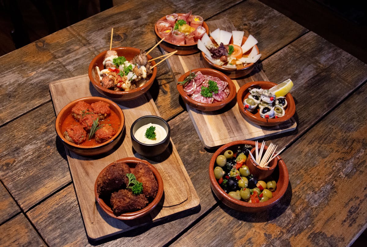 Things to Do in Madrid: The Ultimate Guide to Madrid's Best Attractions & Activities 8 Traditional Spanish tapas served on rustic wooden boards