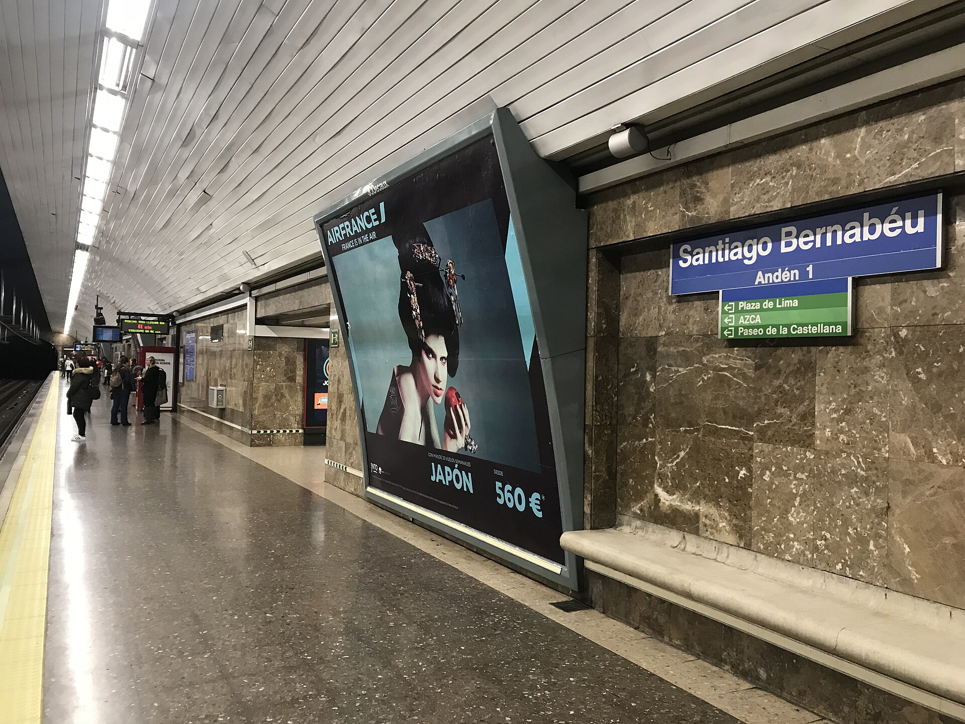 A Metro platform with marble walls and a blue sign reading Santiago Bernabéu, Andén 1, with exits to Plaza de Lima, AZCA and Paseo de la Castellana